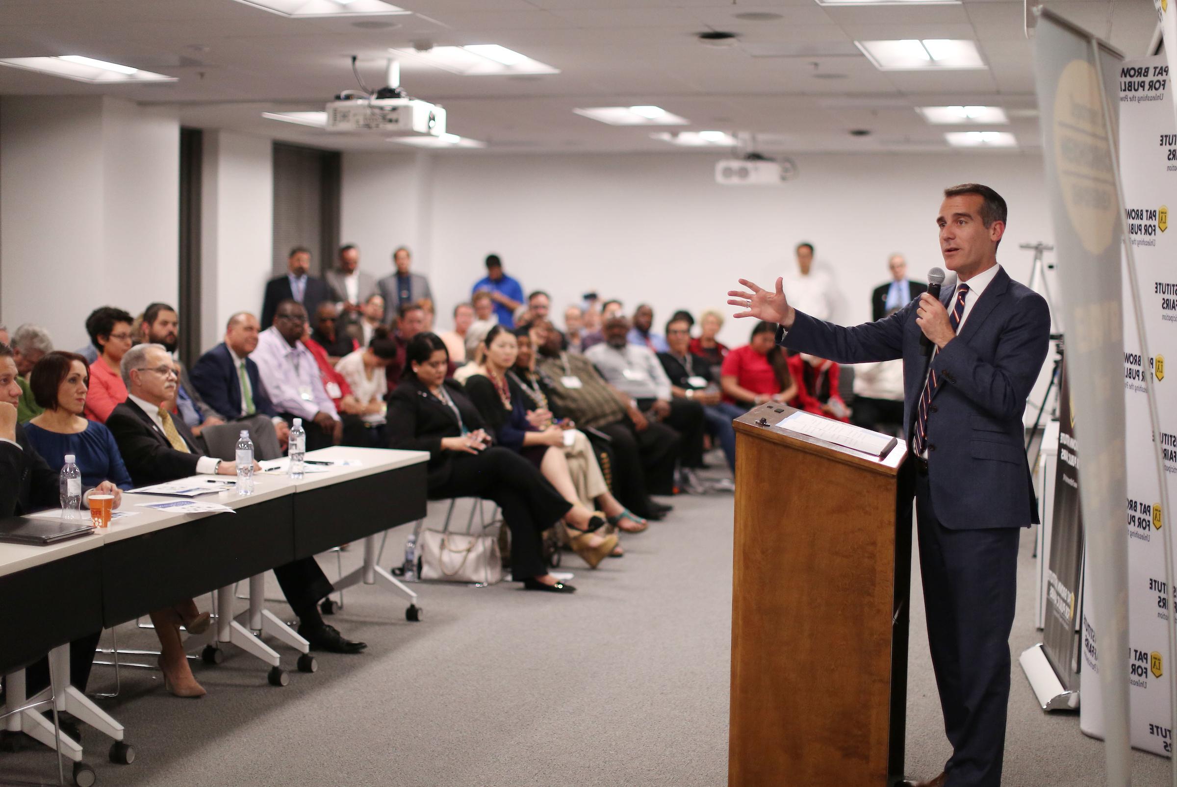 Mayor Eric Garcetti speaks with a microphone to a room full of participants of Civic University, a program organized by the Pat Brown Institute for Public Affairs at Cal State LA.
